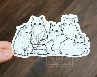 Könnte beinhalten: Ein gestanzter Aufkleber mit einer schwarz-weißen Strichzeichnung von fünf Katzen in verschiedenen Posen. Das Design enthält den Text Katrina Wold und @Katrinawoldart, der in einem kleinen Kasten unten rechts und an der Seite gedruckt ist.