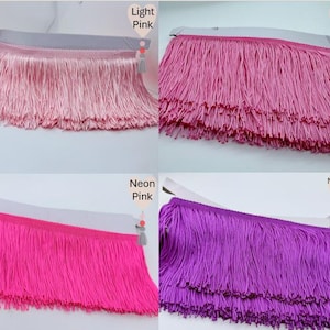 Pode incluir: Quatro amostras de franjas presas a uma fita de cabeçalho cinza. As cores estão rotuladas como Light Pink, Pink, Neon Pink e Magenta. Cada amostra apresenta fios longos, finos e pendentes de cor consistente e textura densa.