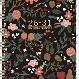 May include: A spiral-bound monthly planner with a dark brown cover featuring a botanical pattern of pink flowers, red apples, pears, pinecones, and green pine branches. The text 26-31 MONTHLY PLANNER is printed in gold in the center.