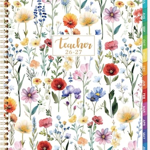 May include: A spiral-bound teacher planner for 26-27 with a white cover featuring a colorful watercolor pattern of various wildflowers including red poppies, yellow daisies, and blue blossoms. The center displays the text Teacher 26-27.