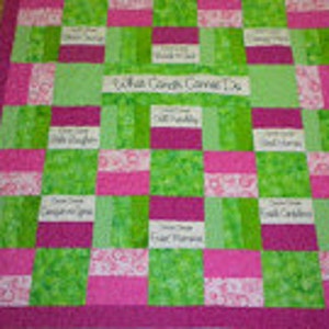 May include: A green and pink patchwork quilt with squares of fabric featuring various inspirational quotes. The center square reads "What God Can't Do Doesn't Exist".