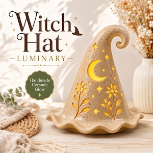 Peut inclure: Une lanterne en céramique beige mouchetée en forme de chapeau de sorcière avec des découpes en forme de croissant de lune, d'étoiles et de fleurs. Le chapeau a une pointe courbée et un bord ondulé. Le texte "Witch Hat LUMINARY" est présent.