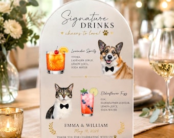 May include: An arched acrylic sign titled Signature Drinks featuring illustrations of a dog and cat wearing bow ties, alongside cocktail recipes for a Lavender Spritz and Elderflower Fizz, personalised with the names Emma & William and May 18, 2024.