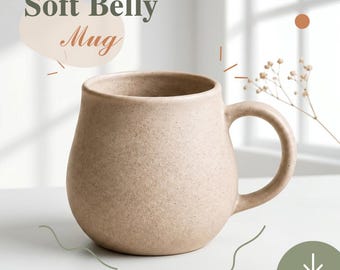 May include: A beige ceramic mug with a rounded, bulbous body and a curved handle. The surface has a speckled, matte texture. Text on the image reads Soft Belly Mug and Digital Template with a downward arrow icon in a green circle.