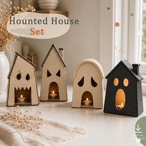 May include: A Haunted House Set featuring four ceramic house-shaped candle holders. Three are light beige with cut-out ghost faces and one is black with a ghost face. Each house contains a small lit tea light candle inside the open doorway.