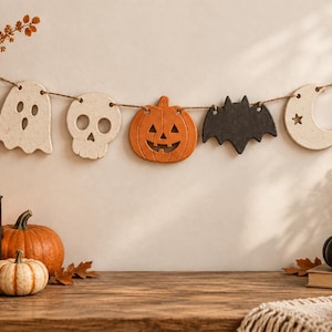 May include: A Halloween-themed garland featuring five hanging ornaments strung on twine: a speckled white ghost, a speckled white skull, an orange jack-o'-lantern, a solid black bat, and a speckled white crescent moon with a star cutout.