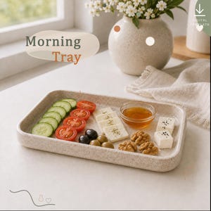 Könnte beinhalten: Ein rechteckiges, gesprenkeltes beiges Tablett mit Gurkenscheiben, Tomatenscheiben, weißen Käsewürfeln, einer kleinen Glasschale mit Honig, grünen Oliven und Walnüssen. Der Text "Morning Tray" ist in der oberen linken Ecke des Bildes zu sehen.
