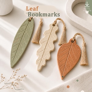 May include: Three leaf-shaped bookmarks with speckled textures in sage green, cream, and terracotta. Each bookmark features a central vein detail, a hole at the top, and a hanging beige tassel. The text Leaf Bookmarks is visible at the top.