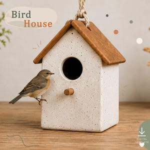 May include: A hanging bird house with a speckled off-white body, a brown wooden roof, and a circular entrance hole. A small brown bird is perched on the side. The text "Bird House" is visible in the upper left corner, and a download icon is present.