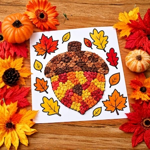 Könnte beinhalten: Ein quadratisches weißes Blatt Papier mit einem zentralen Eichel-Bastelprojekt aus zerknüllten braunen, orangen und gelben Papierstücken, umgeben von illustrierten Herbstblättern in Rot, Orange und Gelb, akzentuiert durch künstliche Kürbisse.