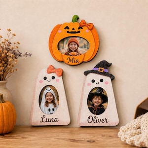 Peut inclure: Trois cadres photo en bois en forme de personnages d'Halloween : une citrouille orange étiquetée Mia, un fantôme blanc avec un nœud orange étiqueté Luna et un fantôme blanc avec un chapeau de sorcière noir étiqueté Oliver, chacun avec un portrait.