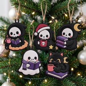 May include: Five embroidered hanging ornaments featuring cartoon characters: a grim reaper reading, a reaper in a Santa hat with a mug, a reaper holding books, a ghost with a scarf reading, and a black cat with a mug on a book, all with twine loops.