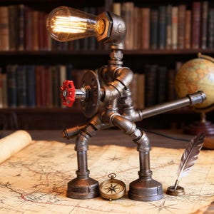 May include: A table lamp constructed from dark metallic industrial pipes, shaped like a standing figure with a glowing Edison bulb head. The lamp features a prominent red circular valve handle on its chest and a long pipe arm extending outward.