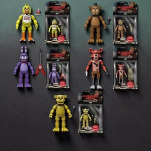 May include: Five Nights at Freddy's action figures including Chica, Freddy, Bonnie, Foxy, and Golden Freddy. Each character is displayed both as a loose figure and inside its original blister pack packaging with included accessories like guitars and microphones.