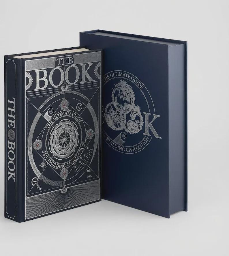 Może przedstawiać: Ciemnoniebieska książka w twardej oprawie z pasującym etui. Na przedniej okładce znajduje się srebrny napis THE BOOK oraz THE ULTIMATE GUIDE FOR BUILDING CIVILIZATION, a także skomplikowane geometryczne ilustracje liniowe.