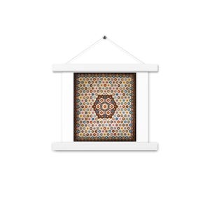 Puede incluir: Un tapiz cuadrado con un patrón hexagonal repetitivo en tonos marrón, azul, naranja y crema. La obra de arte está sujeta por un marco de madera blanca con una barra superior e inferior y un cordel fino para colgarla de un solo punto.