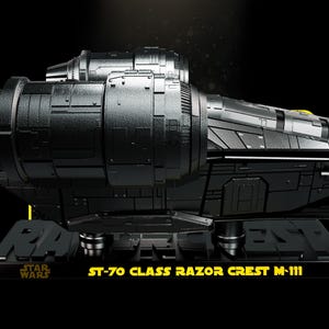 May include: A black ST-70 Class Razor Crest M-111 model spaceship featuring a detailed metallic finish, large side engines, and a rectangular base with the text ST-70 CLASS RAZOR CREST M-111 and the Star Wars logo printed in yellow.