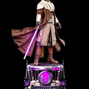 Puede incluir: Una figura coleccionable de Mace Windu sobre una base circular con iluminación púrpura. El personaje viste una túnica marrón sobre una prenda beige, hombreras blancas y botas marrones. Sostiene un sable de luz de color púrpura brillante.