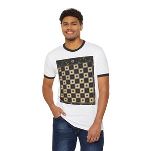 May include: A white ringer t-shirt with black trim on the collar and sleeves, featuring a large, centred graphic of a square checkerboard pattern in shades of black, cream, and dark brown, with circular details inside each individual square.