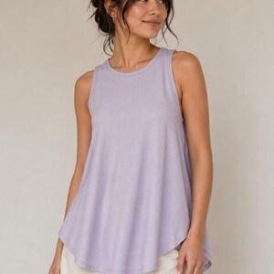 Peut inclure: Un d&eacute;bardeur sans manches de couleur violet clair avec une encolure ronde et une finition en tissu textur&eacute; et c&ocirc;tel&eacute;. Le v&ecirc;tement pr&eacute;sente une silhouette &eacute;vas&eacute;e et d&eacute;contract&eacute;e qui tombe librement depuis les &eacute;paules.
