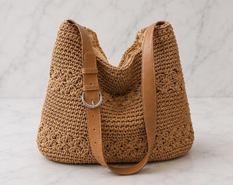 May include: A tan crochet hobo bag featuring a textured star-like pattern throughout the body. The bag includes a smooth tan faux leather shoulder strap with an adjustable silver-toned metal buckle and a matching tan fabric interior lining.