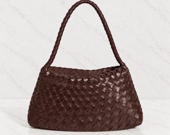 May include: A dark brown handbag featuring an intricate woven leather pattern across the entire body. The bag has a single, rounded, braided leather handle attached to the top, creating a structured yet flexible silhouette for carrying.