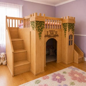 Op de afbeelding: Een houten hoogslaper in de vorm van een kasteel met een trap aan de linkerkant, een glijbaan aan de rechterkant en een centrale boogopening. De structuur is voorzien van decoratieve groene klimopranken, een houten monogram met de letters LWF en een reling.