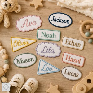 May include: A collection of embroidered fabric name patches in various shapes including ovals, rectangles, triangles, and scalloped clouds. Each patch features a unique name stitched in colored thread, including Ava, Jackson, Noah, Olivia, Ethan, Lila, Mason, Hazel, Leo, and Lucas.