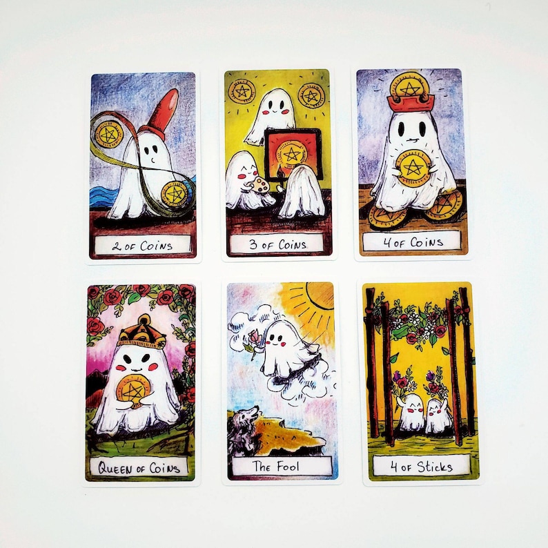 以下が含まれることがあります： 幽霊のイラストが描かれた6枚のタロットカード。カードには「2 of Coins」「3 of Coins」「4 of Coins」「Queen of Coins」「The Fool」「4 of Sticks」と書かれています。各カードには、カラフルな手描きのシーンの中に白い幽霊のキャラクターが描かれています。
