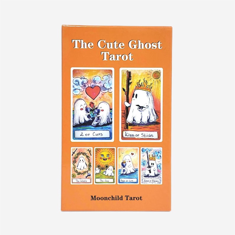 以下が含まれることがあります： Moonchild Tarotによる「The Cute Ghost Tarot」と題されたオレンジ色の長方形のタロットカードデッキボックス。表面には「2 of Cups」、「King of Sticks」、「The World」、「The Sun」、「Page of Cups」、「King of Blades」など、様々なカードに描かれたゴーストキャラクターのイラストがデザインされています。