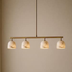 May include: A linear pendant light fitting featuring a long, horizontal brass rod suspended by a single vertical stem. Four dome-shaped shades made of white marble with grey veining are attached to the rod, each housing an internal light source.