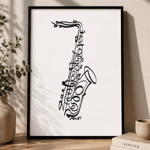 Pode incluir: Uma impressão de arte de parede emoldurada apresentando um desenho de linha preta de um saxofone criado com letras cursivas fluidas e contínuas. A obra de arte é definida contra um fundo branco liso e fechada em uma moldura preta simples, exibindo um instrumento musical.