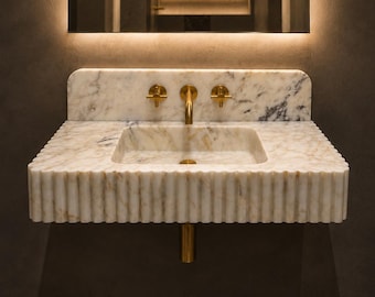 Lavabo mural de mármol Calacatta Gold estriado con protector contra salpicaduras