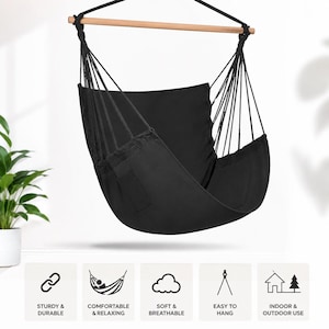 May include: A black hanging hammock chair featuring a solid black fabric seat and backrest, suspended by black ropes from a horizontal wooden spreader bar. The chair includes a matching black cushion and is designed for suspension from above.