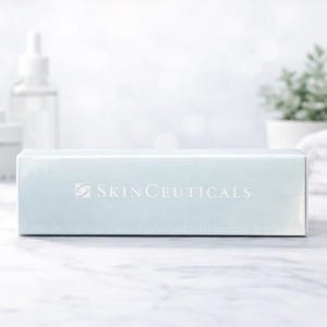 May include: A rectangular light blue product box featuring the white text SKINCEUTICALS and a small logo on the front. The box has a smooth, reflective surface and is positioned horizontally, displaying clear branding across its center.