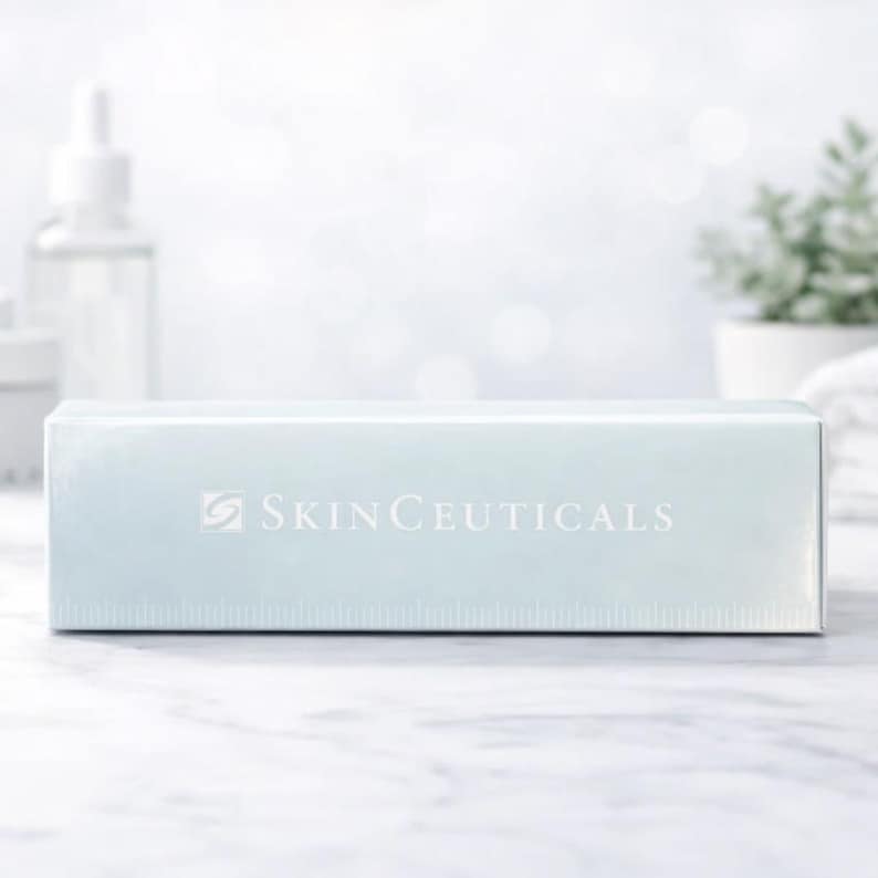 May include: A rectangular light blue product box featuring the white text SKINCEUTICALS and a small logo on the front. The box has a smooth, reflective surface and is positioned horizontally, displaying clear branding across its center.