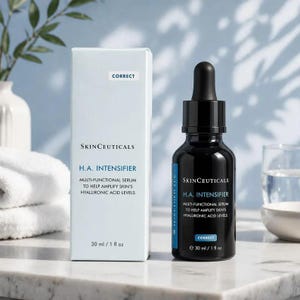 May include: A SkinCeuticals H.A. Intensifier multi-functional serum bottle and its matching light blue box. The black glass dropper bottle and box both feature the text SkinCeuticals H.A. Intensifier, 30 ml / 1 fl oz, and Correct. The set is displayed upright.