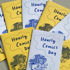 A collection of mini zines called Hourly Comics Day, some printed on yellow paper and some on lilac, spread out on a grey background.