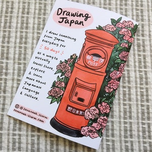 The back cover of a zine called 'Drawing Japan' with a drawing of a Japanese post box surrounded by hydrangea flowers.