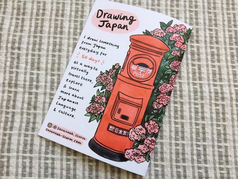 The back cover of a zine called 'Drawing Japan' with a drawing of a Japanese post box surrounded by hydrangea flowers.
