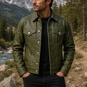 Puede incluir: Una chaqueta de cuero verde oliva con cuello clásico, mangas largas y cierre frontal de botones metálicos plateados. La chaqueta incluye dos bolsillos en el pecho con solapas abotonadas y detalles de costuras verticales en los paneles frontales.