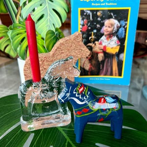 Four sweet items- Sweden. A wonderful glass Dala horse - Lindshammar Swedish, A 1980s Swedish booklet and 2 Dala horses. Fun display.