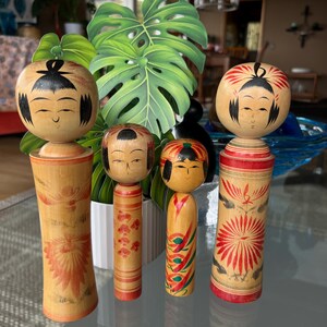 four delightful & collectible traditional Kokeshi dolls.   Beautifully made with pretty designs. Lovely signed collectibles. Made in Japan.