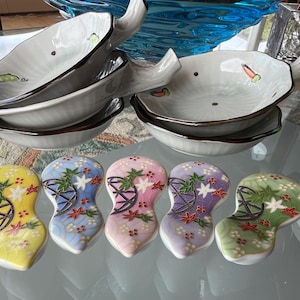 A fun sushi set. 5 ornate Japanese chopstick rests and 5 adorable Japanese rice/sushi/soy sauce dishes.A fun little treat/sushi set.