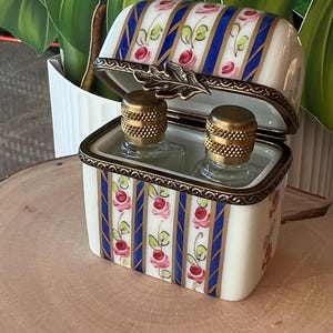 An elegant vintage 1960s Limoges perfume case with perfume bottles. Beautiful hand painted floral designs with blue and gold stripes.