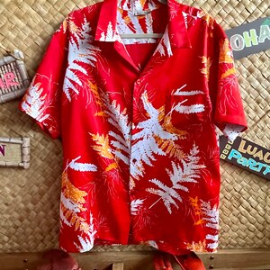 Get the Tiki party started. Fab silky tiki time Aloha shirt in red with orange & white accents. Made in Hawaii.