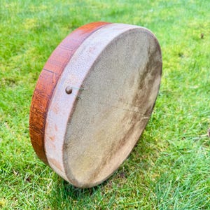 A vintage Bendir drum with wood base, stretched hide and internal snares.
