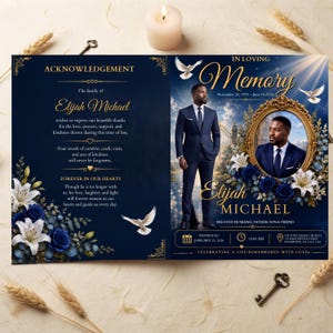 May include: A funeral program featuring a dark blue background with gold text, white lilies, and blue roses. The front displays a portrait of a man in a suit within an ornate gold frame, doves, and the text In Loving Memory, Elijah Michael.