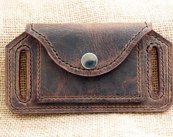 May include: A brown leather knife sheath with a snap closure and belt loops.