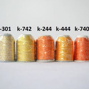 May include: Five spools of metallic thread in various colors, including gold, silver, and orange. The spools are labeled with the following codes: k-301, k-742, k-244, k-444, and k-740.